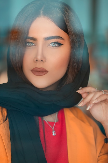 Free photo female model in black hijab and orange jacket