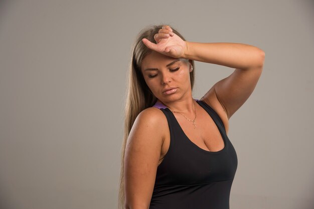 Female model in sport bra holds her head. 