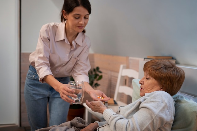 Free photo female nurse taking care of elderly person