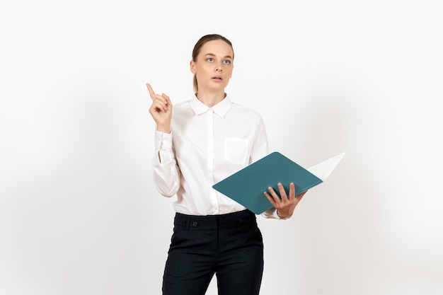 female office employee in white blouse holding and reading blue file on white