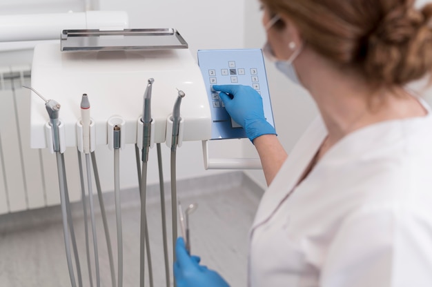 Female orthodontist with latex gloves handling dental equipment