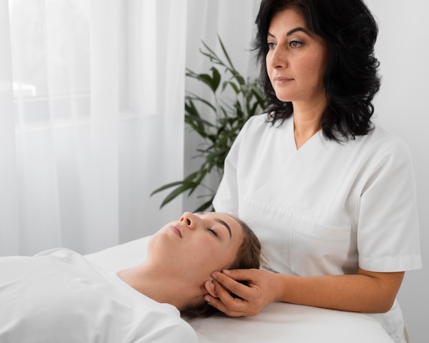 Female osteopathist treating a patient indoors