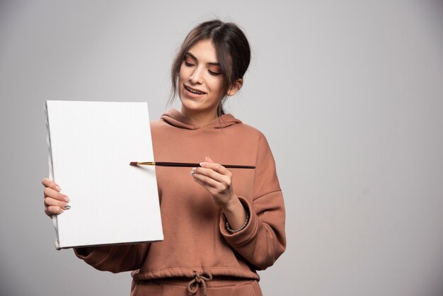 Female painter posing with paint brushe and canvas