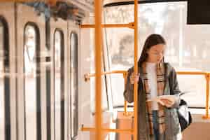 Free photo female passenger reading and travelling by tram