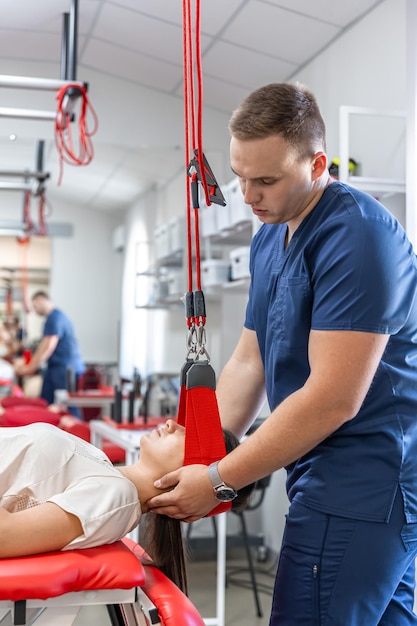 Free Photo female patient hanging on suspensions at rehabilitation center