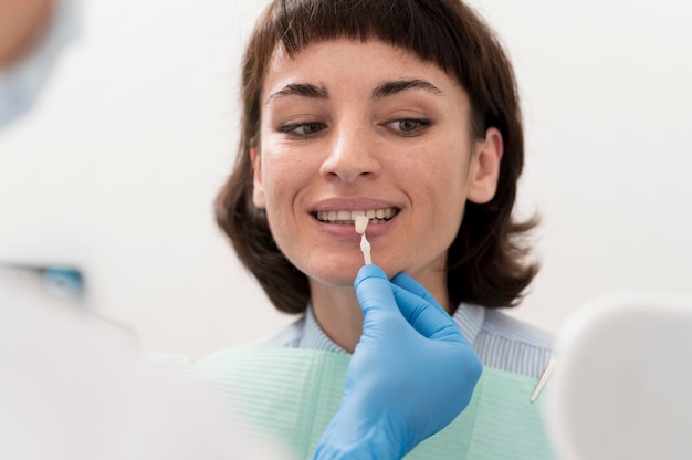 Free photo female patient looking in the mirror at the dentist's office