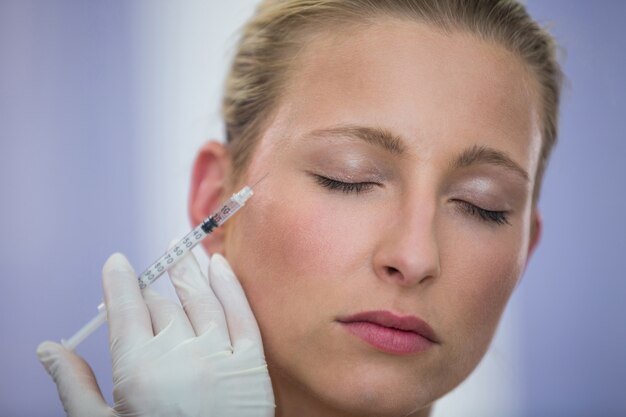 Female patient receiving a botox injection on face