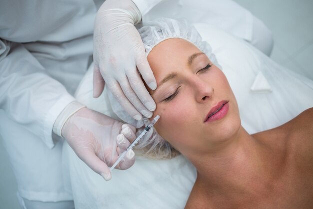 Female patient receiving a botox injection on face