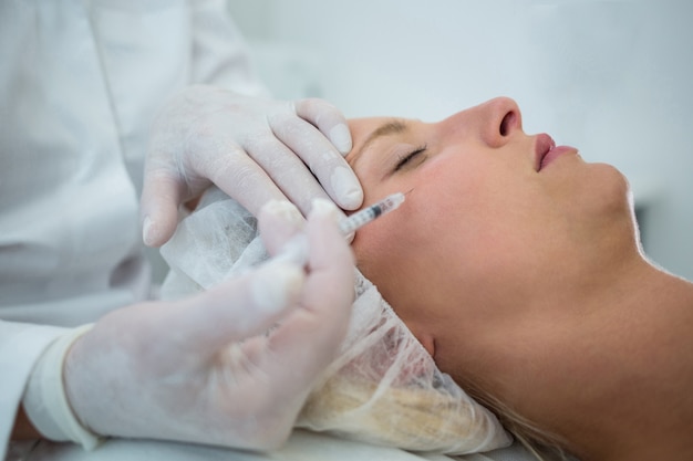 Free photo female patient receiving a botox injection on face