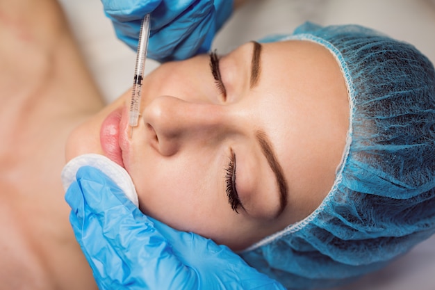 Female patient receiving an injection on her face