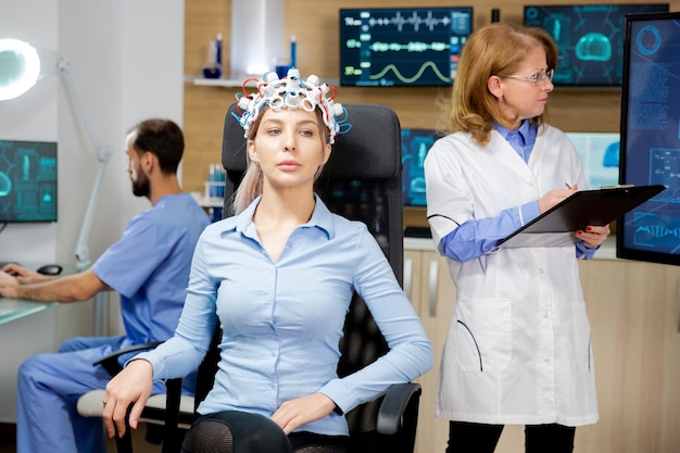 Free photo female patient who is concentrated during a brain wave scanning device test. doctor scanning brain