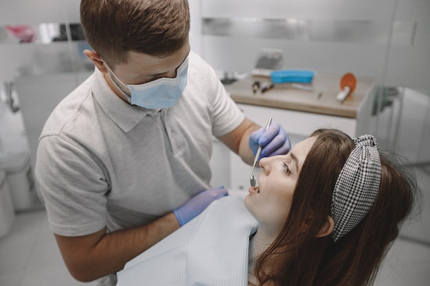 Free photo female patient with braces has dental examination at dentist office. woman wearing white clothes