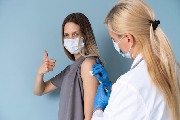 Free photo female patient with medical mask getting a vaccine