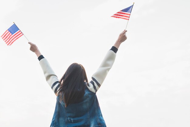 Female patriot with flags in outstretched hands