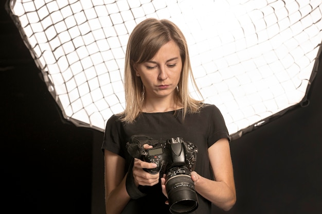 Free photo female photographer adjusting her camera