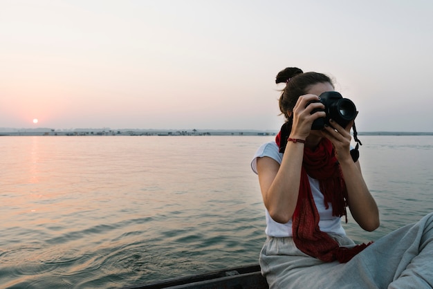 Free Photo female photographer sitting on a boat on the river ganges