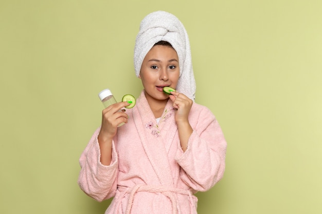 Free photo female in pink bathrobe holding spray flask