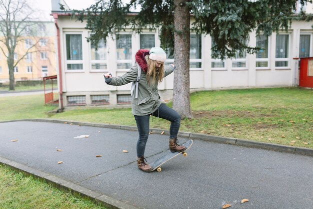 Female practicing on skateboard on walkway