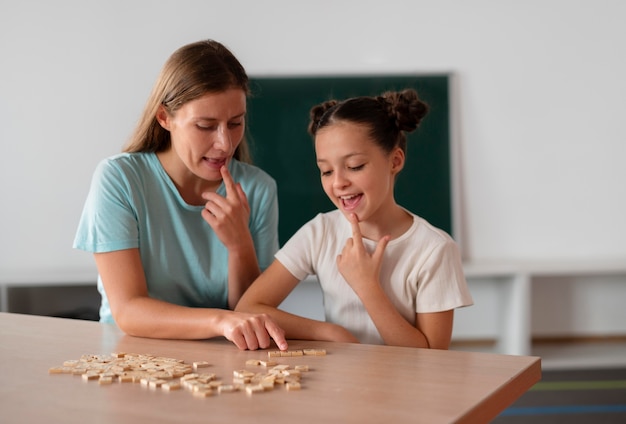 Free photo female psychologist helping a girl in speech therapy