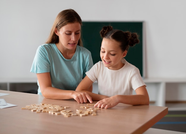 Female psychologist helping a girl in speech therapy