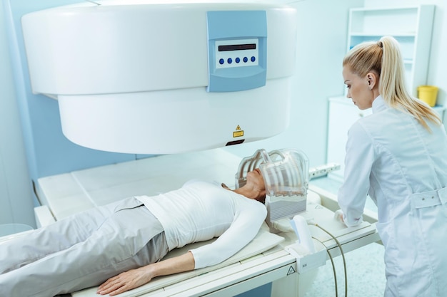 Free photo female radiologist and mature patient during ct head scan examination at clinic