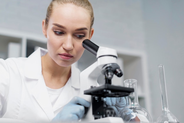 Free photo female researcher in the laboratory with microscope