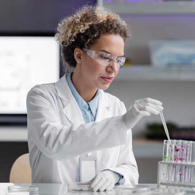 Female researcher in the laboratory with safety glasses and test tubes