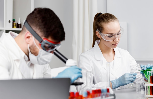 Free photo female researcher with gloves and test tubes in the lab