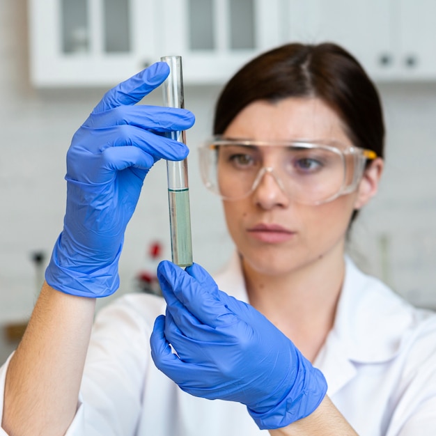 Female researcher with safety glasses and test tube