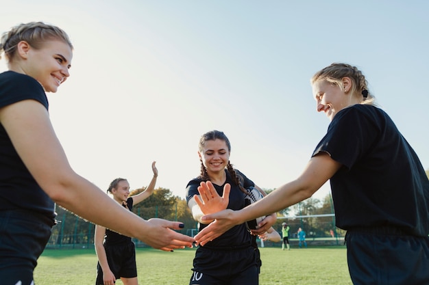 Free photo female rugby players putting hands together