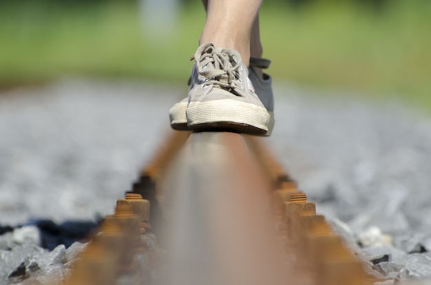 Free Photo female's feet balancing on railroad tracks