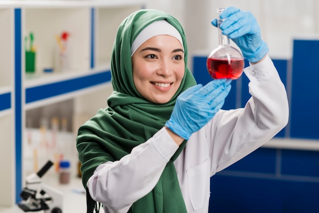 Female scientist with hijab looking at substance in the lab