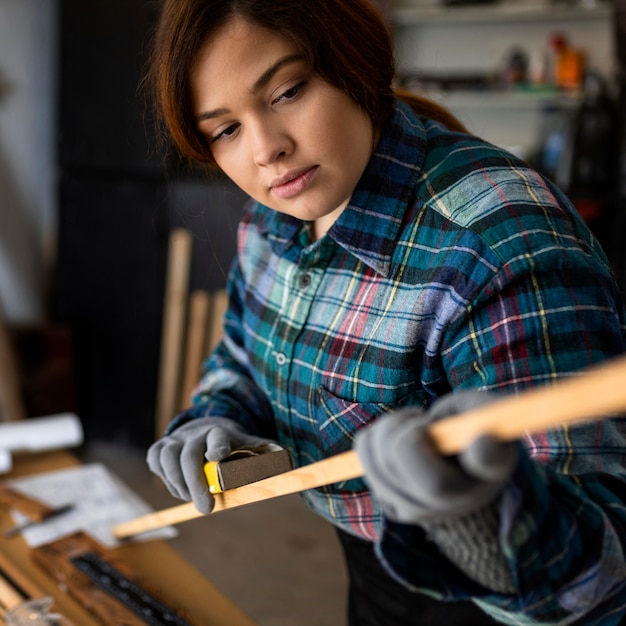 Free photo female scrapping wood plank