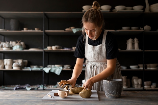 Female sculptor working with clay in the studio