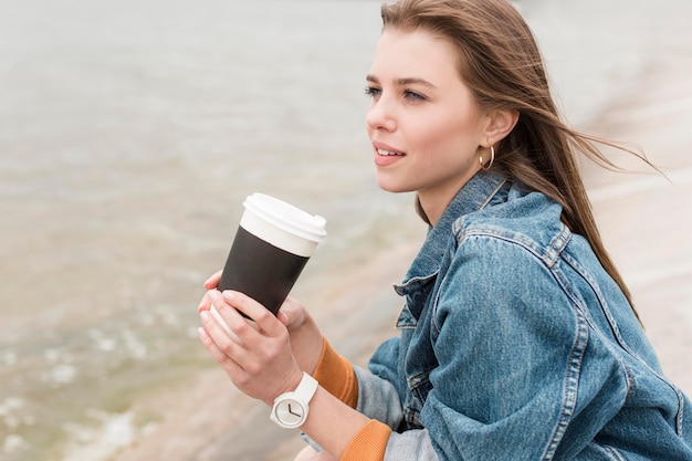 Free photo female at seaside with coffee