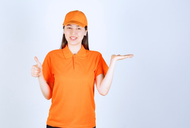 Female service agent wearing orange color dresscode and showing positive hand sign