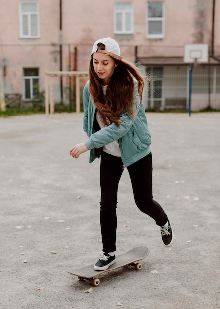 Free photo female skater practicing skateboarding outdoors