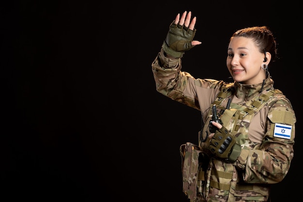 Female soldier in camouflage with grenade black wall