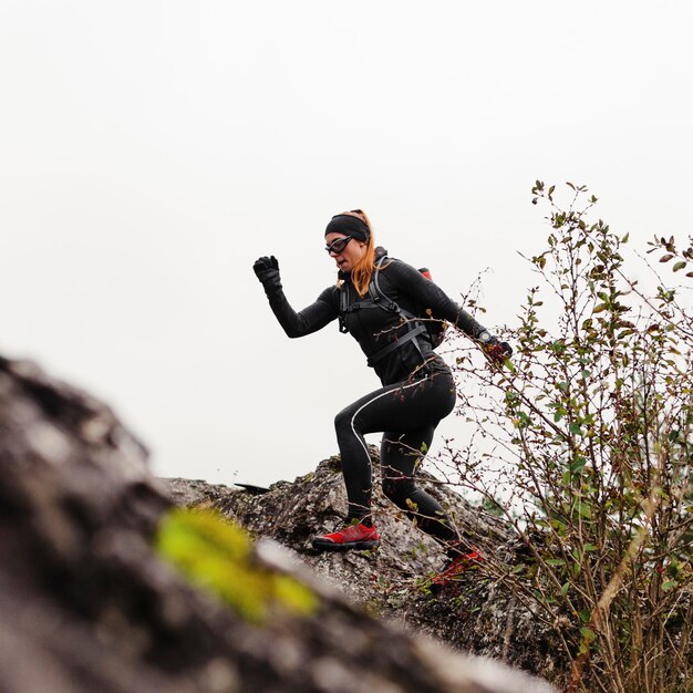 Female sporty jogger running on stones