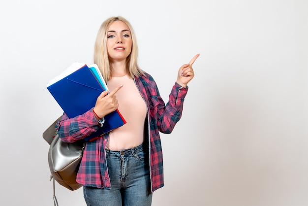 female student holding different files on white