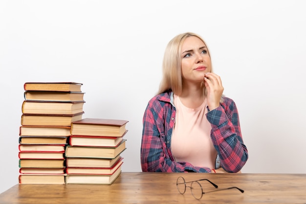 Free photo female student just sitting with books thinking on white