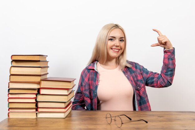 female student just sitting with books on white