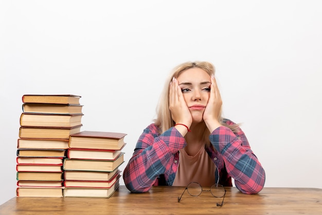 Free photo female student just sitting with different books tired on white