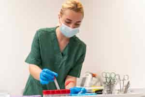 Free photo female student at medicine wearing medical mask while doing her practice