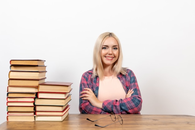 Free photo female student sitting with different books on white