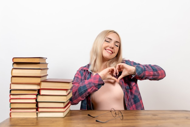 Free photo female student sitting with different books on white