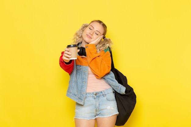 Free photo female student young in modern clothes holding coffee desiring to sleep