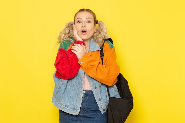 Free Photo female student young in modern clothes posing with surprised expression on yellow