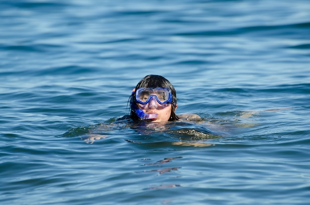 Female swimming in the water with a diving mask