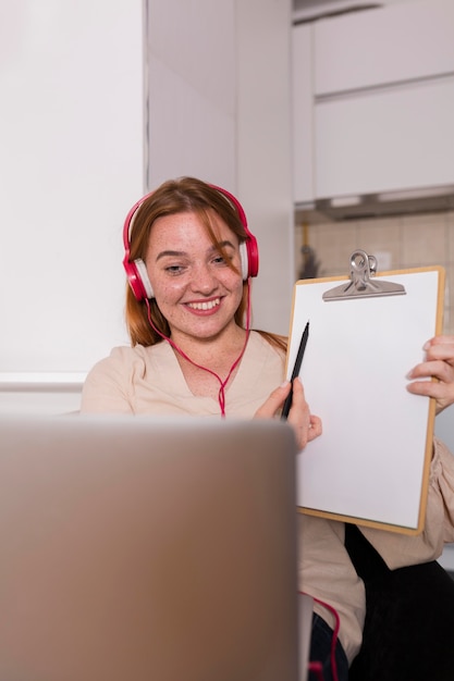 Free photo female teacher showing students in online class the lesson on notepad